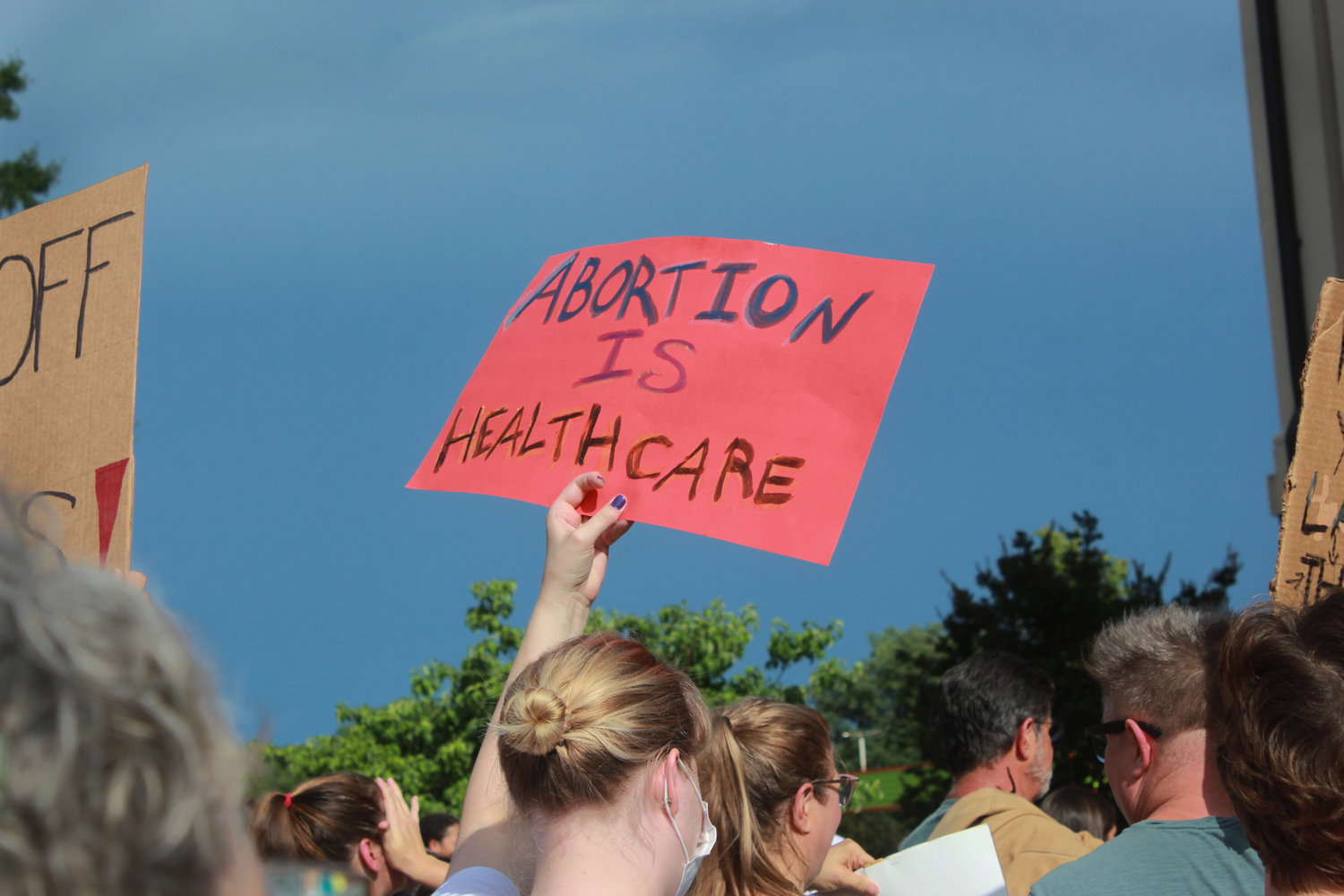 A sign that reads 'abortion is healthcare' is lifted into the air during the abortion and women’s rights protest on Monday outside of the Historic Courthouse in Pittsboro. Some of the chants spoken during the rally included, 'Hey hey, ho ho, the Supreme Court has got to go' and 'Abortion rights are human rights.'